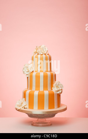 Orange gestreift Hochzeitstorte mit Pfirsich Hintergrund Stockfoto