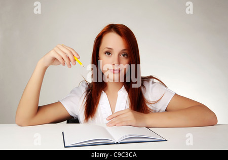 junge gut aussehende Frau in ein großes Notebook schreiben Stockfoto