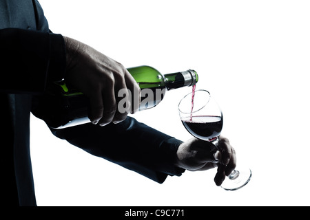 ein kaukasischer Mann Hände Detail strömenden Rotwein in einer Glas-Silhouette in weißem Hintergrund Studio isoliert Stockfoto