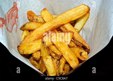 Pommes Frites-Kartoffel, die Pommes frites im Entenfett gesalzen gebraten serviert in einer Papier-Membran Stockfoto