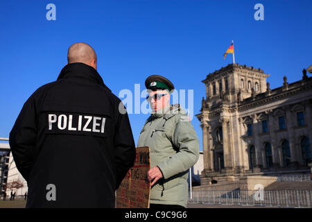 Ein Polizist, der vor dem Reichstagsgebäude in Berlin einen Protestierenden befragt, der historische Rechte für Gebiete in Ostdeutschland fordert Stockfoto