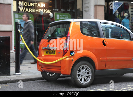 Eine kleine, orange Elektroauto verbunden zu einer Straße Laden Punkt, Covent Garden, London UK Stockfoto