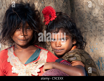 Glücklich armen indischen nomadischen Bettler Mädchen gegen einen Baum. Andhra Pradesh, Indien Stockfoto