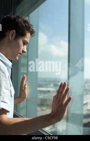 Mann aus Fenster, Seitenansicht Stockfoto