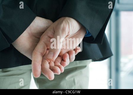 Gefalteten Händen hinter dem Rücken, hintere Ansicht, beschnitten Stockfoto