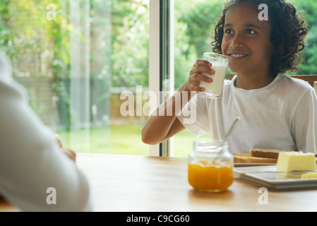 Mädchen trinken Glas Milch zum Frühstück Stockfoto