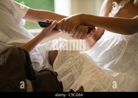 Kinder kämpfen über Fernbedienung, beschnitten Stockfoto