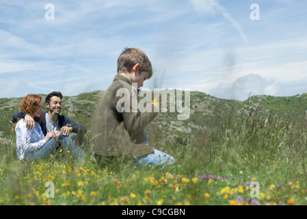 Eltern und Jugendliche junge sitzt auf Wiese Stockfoto