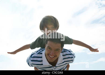 Vater mit Sohn auf Rücken, Porträt Stockfoto