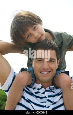 Junge, Reiten auf seines Vaters Schultern, Porträt Stockfoto