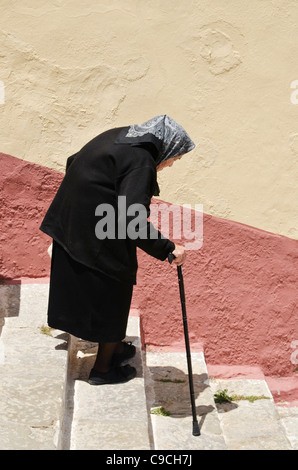 Alte griechische Frau, gekleidet in schwarz in der alten Chorio, Insel Symi, Griechenland Stockfoto