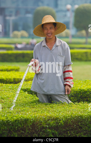 GUANGZHOU, Provinz GUANGDONG, CHINA - Arbeiter, die Bewässerung von Pflanzen in der Stadt Guangzhou. Stockfoto