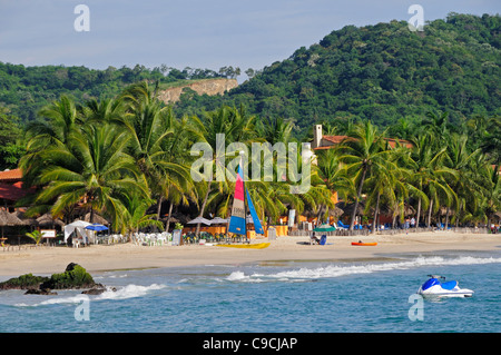 Mexiko, Guerrero, Zihuatanejo, Blick auf Playa la Ropa Kokospalme gesäumten Strand. Stockfoto