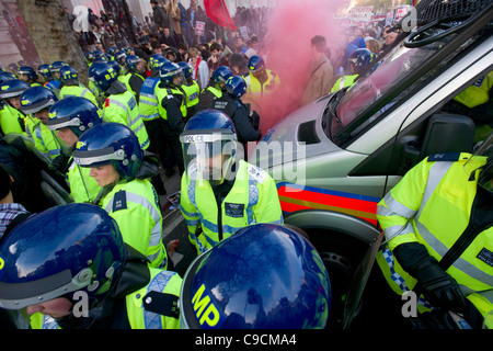 Polizei in Aufruhr Getriebe bildet eine Barriere auf Whitehall, gebadet in roten Rauch aus einem Flare, Studentendemonstration, London, England Stockfoto