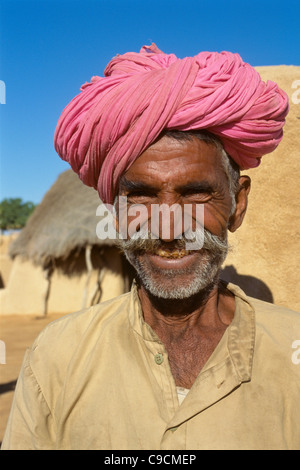 Lächelnder Rajasthani-Mann in hell rosa Turban, Varana Dorf, in der Nähe von Jaisalmer, Rajasthan, Indien Stockfoto