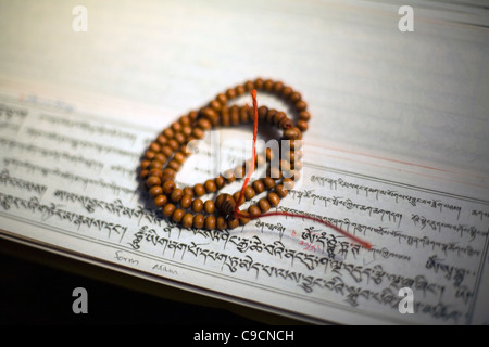 Buddhistischen Gebetsperlen sitzen oben auf Sutras am Vajra Vidya Institut für buddhistische Studien in Sarnath, Indien Stockfoto