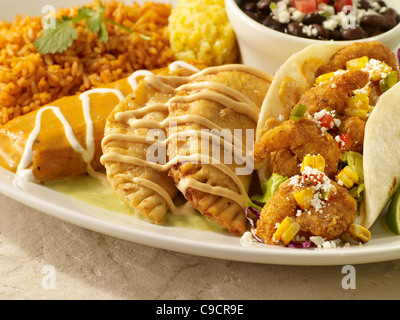 Ein Taco Shrimps, zwei Empanadas und ein Tamale in Soße bedeckt und serviert mit spanischen Reis und schwarze Bohnen Stockfoto
