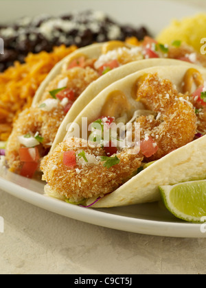 Zwei gebratene Garnelen Tacos serviert mit spanischen Reis und schwarze Bohnen Stockfoto