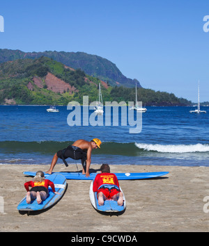 Surflehrer zeigt, bewegt sich in Hanalei Beach auf Kauai Stockfoto