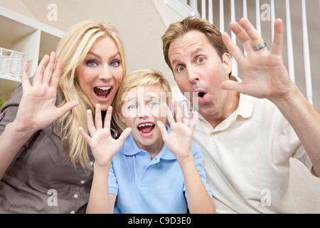 Eine attraktive glückliche, lachende Familie von Mutter, Vater und Sohn sitzen auf einem Sofa zu Hause Spaß Stockfoto