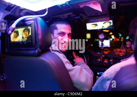 Ein Taxifahrer fahren einen geschmückten Taxi mit elektronischen Geräten in Tel Aviv Israel Stockfoto