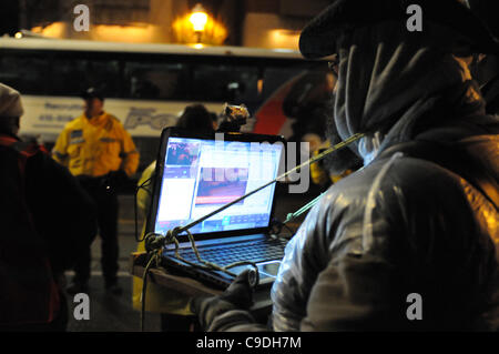 23. November 2011, bereitstellen Toronto Polizei in großer Zahl vor Sonnenaufgang heute Morgen beginnen die vertreiben die besetzen Toronto-Zelt-Camp vom St. James Park. Hier ein nicht identifizierter Protest freiwillig live-Streams die Veranstaltung von seinem Laptop. Stockfoto