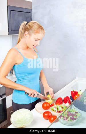 Junge Frau in der Küche Schneiden von Gemüse Stockfoto