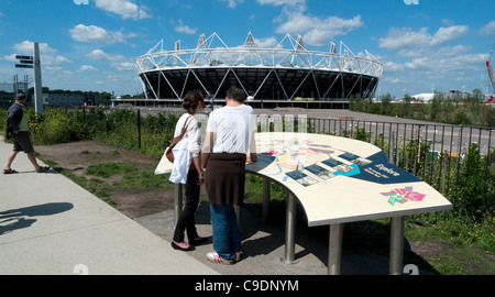 Ein paar studieren eine Informationstafel 2012 Olympic Park und Blick auf das Stadion aus der Sicht Tube Greenway Gegend, London 2011 Stockfoto