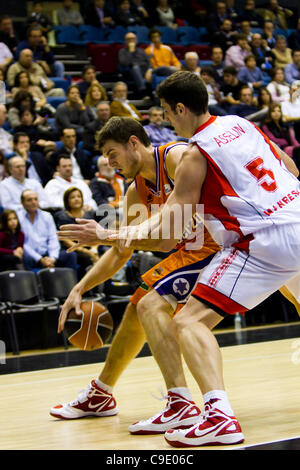 26.11.2011. Valencia, Spanien Basketball-Match zwischen Valencia Basket Club und Assignia Manresa, Spieltag 9 Liga Endesa - Spanien---Thiago Splitter, Valencia Basket Club-Spieler, Prellen des Balls Vorbereitung eine Bewegung gegen Josh Asselin Form Assignia Manresa Stockfoto