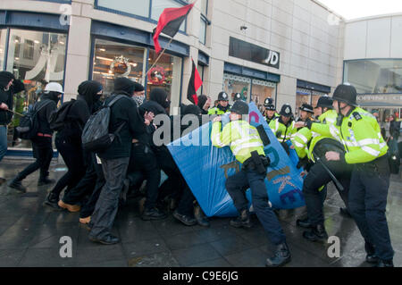 Brighton, UK. 30. November 2011. Anarchisten veer Weg von der vereinbarten Route während des öffentlichen Sektors Streik Marsches in Brighton, aggressiv gegenüber Journalisten und Versuch, aber ausfallen, zum Sturm der Churchill Square Shopping Mall, bevor durch die Polizei zurückgedrängt. Stockfoto