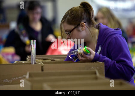 London Ontario, Kanada - 8. Dezember 2011. Katie Hart sortiert durch die Boxen der gespendeten Spielsachen, die eingehen, Weihnachten Spielzeug behindert in 2011 Heilsarmee Spielzeug und Lebensmittel-Laufwerk Distributionszentrum im Inneren des Gebäudes Fortschritte bei Western Fair District. In diesem Jahr erwartet die Heilsarmee, provi Stockfoto