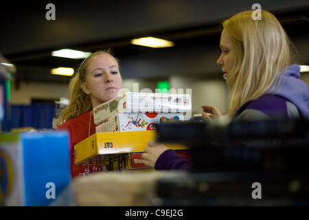 London Ontario, Kanada - 8. Dezember 2011. Kaila Swain, Emma Beauchamp rechts und Links sammeln Spielzeug und Spiele zu Weihnachtsspielzeug behindern in 2011 Heilsarmee Spielzeug und Lebensmittel-Laufwerk Distributionszentrum im Inneren des Gebäudes Fortschritte bei Western Fair District. In diesem Jahr die Heilsarmee-Expe Stockfoto