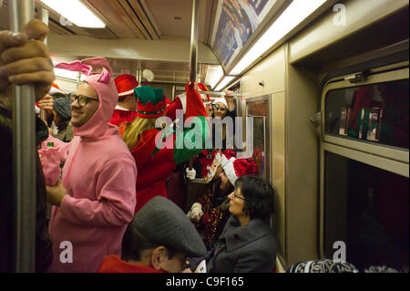 Weihnachten Nachtschwärmer Teilnahme an der jährlichen Santacon fahren mit der u-Bahn in New York auf Samstag, 10. Dezember 2011. Santacon, in erster Linie eine Kneipentour in Santa und andere Weihnachten Kostüme (bis auf einen Teilnehmer, der seinen Urlaub verwechselt habe), zieht Hunderte von Masken gehen im Zusammenhang Stockfoto