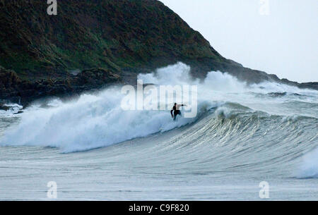 13. Dezember 2011 blieb - Swansea, UK - Surfer, das Beste aus den schweren Brandung Rollen in Langland Bucht, Swansea heute Morgen, als South Wales Küste durch die starken Winde und Regen als Wetterwarnungen zerschlagen ist. Stockfoto