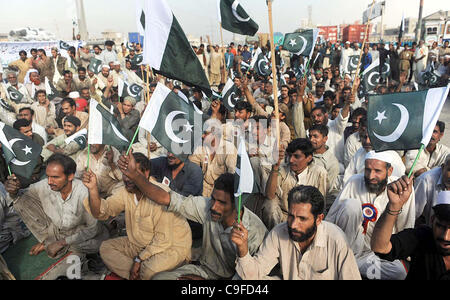 Unterstützer von Autoteilen und Kfz-Techniker-Verband Nationalflaggen zu halten, wie sie gegen NATO-Angriff in dem Land, in Karachi protestieren Stockfoto