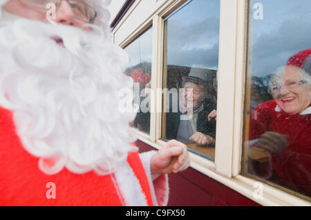 Der Weihnachtsmann und seine Elfen unterhalten und Geschenke für Kinder an Bord der Welsh Highland Railway in Snowdonia North Wales.on 17 Dezember 2011 Stockfoto