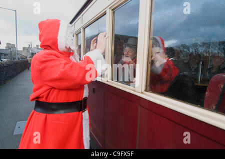 Der Weihnachtsmann und seine Elfen unterhalten und Geschenke für Kinder an Bord der Welsh Highland Railway in Snowdonia North Wales.on 17 Dezember 2011 Stockfoto