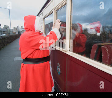 Der Weihnachtsmann und seine Elfen unterhalten und Geschenke für Kinder an Bord der Welsh Highland Railway in Snowdonia North Wales.on 17 Dezember 2011 Stockfoto