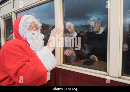 Der Weihnachtsmann und seine Elfen unterhalten und Geschenke für Kinder an Bord der Welsh Highland Railway in Snowdonia North Wales.on 17 Dezember 2011 Stockfoto