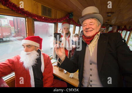 Der Weihnachtsmann und seine Elfen unterhalten und Geschenke für Kinder an Bord der Welsh Highland Railway in Snowdonia North Wales.on 17 Dezember 2011 Stockfoto