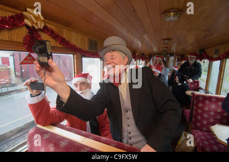 Der Weihnachtsmann und seine Elfen unterhalten und Geschenke für Kinder an Bord der Welsh Highland Railway in Snowdonia North Wales.on 17 Dezember 2011 Stockfoto