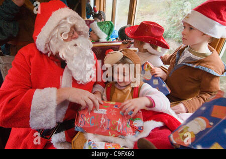 Der Weihnachtsmann und seine Elfen unterhalten und Geschenke für Kinder an Bord der Welsh Highland Railway in Snowdonia North Wales.on 17 Dezember 2011 Stockfoto