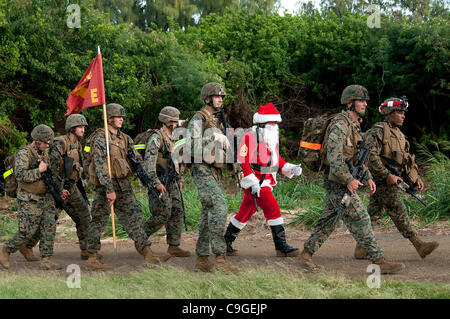 Santa Claus marschiert zusammen mit Marines vom 2. Bataillon, 3. Marine Regiment an der Boondocker Ausbildung 19. Dezember 2011 bei Kaneohe Bay auf Hawaii. Die Marines wurden für Tots Laufwerk an der Marine Corps Base Hawaii Insel Krieger bekämpfen Wettbewerb III und Spielzeug beteiligt. Stockfoto
