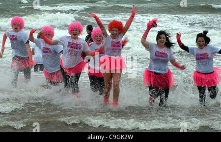 Prestwick, UK. 26. Dezember 2011. Teilnehmer im Kostüm kommen aus dem Wasser nach dem kältesten Bad des Jahres bei der jährlichen CLIC Sargent Charity "Dip mit einem" 2011 in den River Clyde in Prestwick Esplanade, Prestwick. Stockfoto