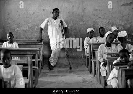 27. September 2010 - Kano, KANO, NIGERIA - Abdullahi Alasan, 18, hat seit vielen Jahren an Kinderlähmung verkrüppelt worden und hat sich Schule bis jetzt nicht leisten können. Die nigerianische Regierung ermöglicht Studierenden mit Polio kostenlos zur Schule zu gehen und er ist in einer Klasse mit 6-10 jährigen in einer Grundschule in Kano, N Stockfoto