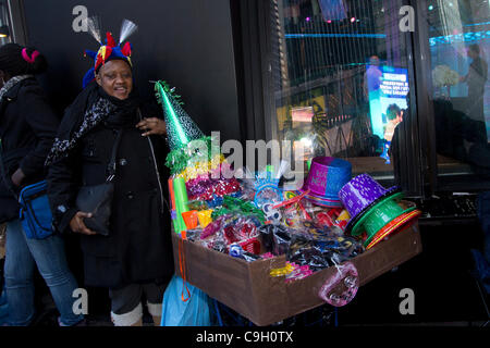 Straßenhändler in New York City Times Square Hüte, Krachmacher und anderen Elementen auf Silvester 2011 zu verkaufen. Lächelnd Publikum in New York City Times Square wartet auf die Ankunft von 2012 auf Vorabend des neuen Jahres. Mehr als 1 Million Menschen aus der ganzen Welt werden schließlich mitfeiern. Stockfoto