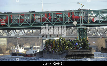 Eine Ponton geschleppt durch ein Boot mit den Blumen, die Menschen in den Sarg des ehemaligen tschechischen Präsidenten Vaclav Havel gebracht auf ein drei-Tage-Reise entlang der Moldau inmitten sonnigem Wetter und großem öffentlichen Interesse in Prag, über dargelegt Samstag, 31. Dezember 2011. Die Organisatoren konzipiert die Veranstaltung als ein sile Stockfoto