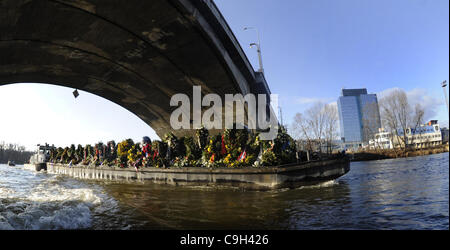 Eine Ponton geschleppt durch ein Boot mit den Blumen, die Menschen in den Sarg des ehemaligen tschechischen Präsidenten Vaclav Havel gebracht auf ein drei-Tage-Reise entlang der Moldau inmitten sonnigem Wetter und großem öffentlichen Interesse in Prag, über dargelegt Samstag, 31. Dezember 2011. Die Organisatoren konzipiert die Veranstaltung als ein sile Stockfoto