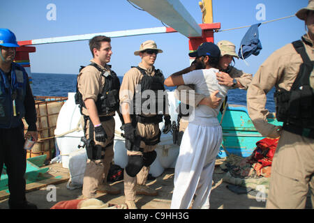 Ein Seemann, geführte Flugkörper Zerstörer USS Kidd Besuch zugewiesen, Board, Durchsuchung und Beschlagnahme Team grüßt ein Crew-Mitglied der iranischen Flagge Angeln Dhau Al Molai nach der Reaktion auf einen Notruf von der Crew, die Gefangenschaft von somalischen Piraten 5. Januar 2012 in das Arabische Meer abgehalten wurde. Die Kidd Stockfoto