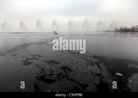 9. Januar 2012 - Srinagar, versucht Kaschmir, Indien - A kaschmirische Muslim sein Boot durch gefrorene Teile von Dal-See in Srinagar, der Sommerhauptstadt des indischen Teil Kaschmirs zu überqueren. Kaschmir-Tal weiterhin unter Sub-Zero Rollen nach dem Schnee Temperaturfall über viele Tage hinweg. (Kredit-Bild: © Altaf Zargar/ZUMAP Stockfoto